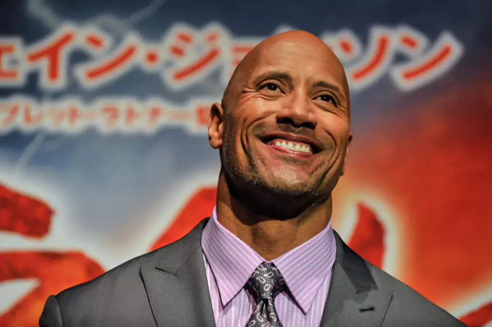 The Rock Singing A Christmas Carol In The Rock Sized Onesie [Video]