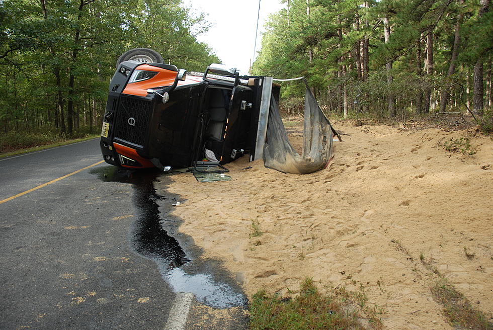 Dump truck overturns spilling 24-tons of sand on side of road in Manchester