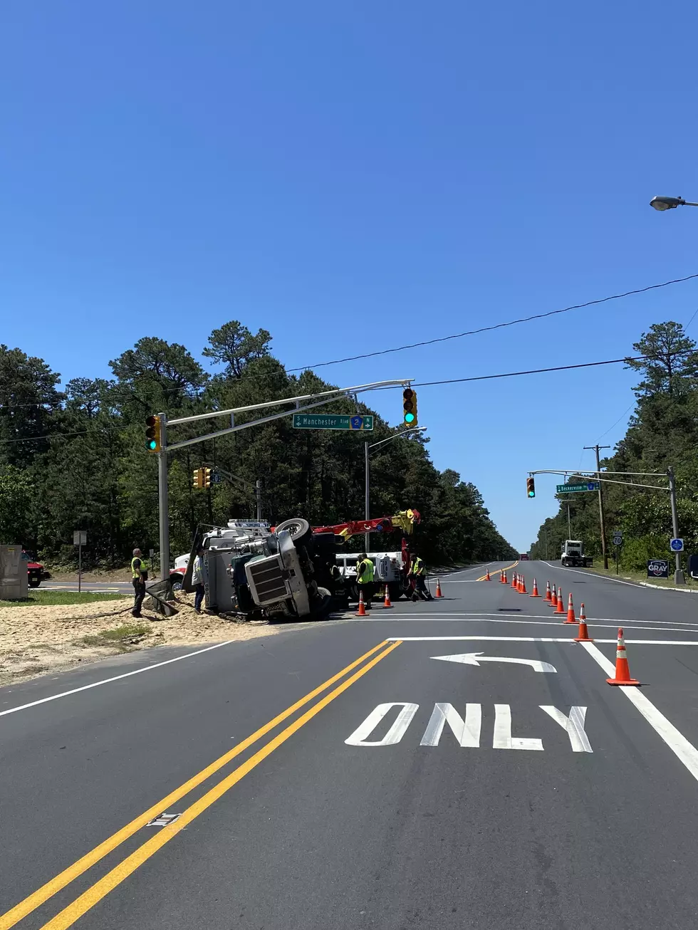 Dump truck carrying 39,000 pounds of sand turns onto its side after accident in Manchester, NJ