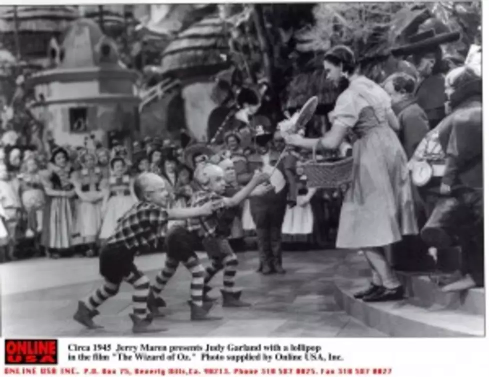 1939: Jerry Maren, playing a Lollipop Guild Member, presents Judy Garland with a lollipop in the film