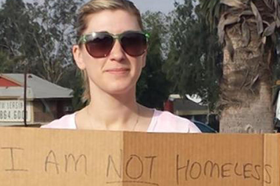 Why is this Woman Holding a Cardboard Sign on a Street Corner? [Photos]