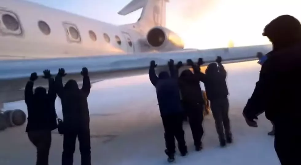 Russian Passengers Get Out and Push Frozen Plane Stuck on the Runway in Siberia