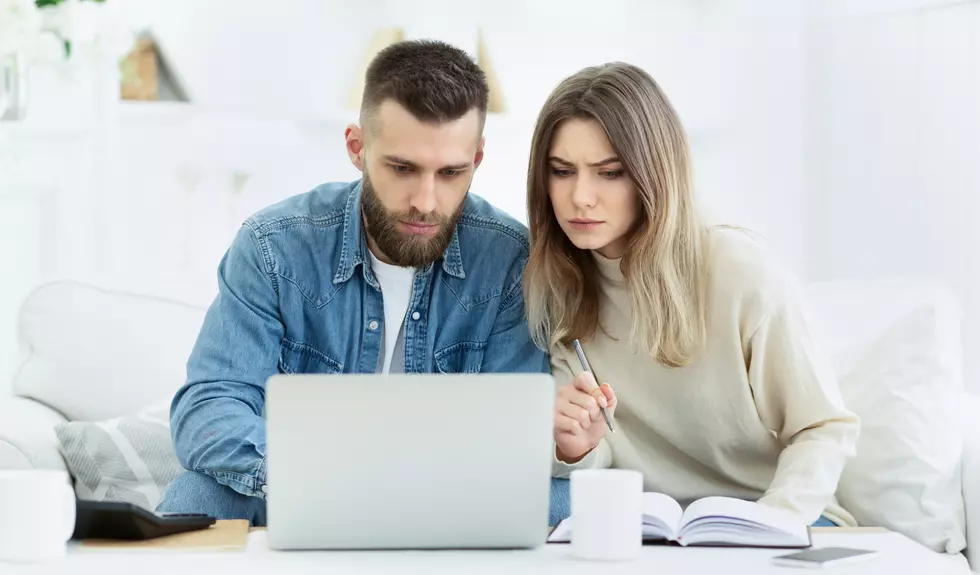 Young couple planning family budget with laptop computer and making notes