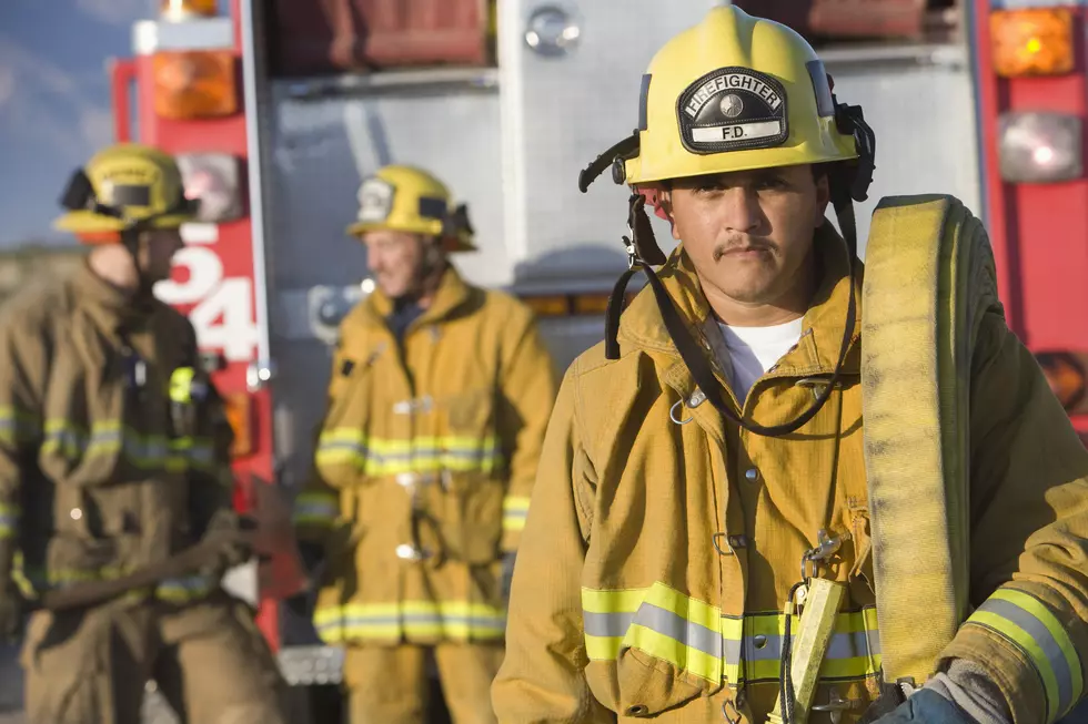 Portrait of firefighter carrying hose