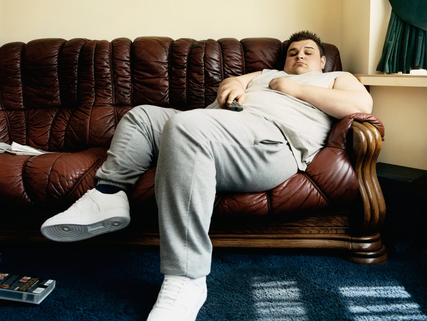 Жирный человек лежит на диване