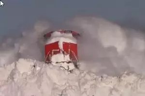 Train Plows Through Snow-Covered Tracks