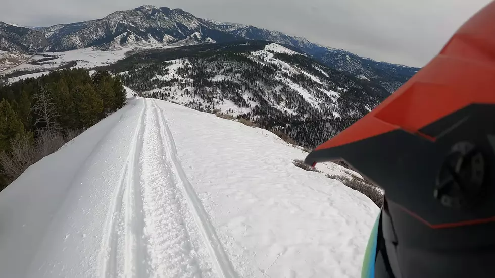 Watch a Snowmobiler Ride a Mountains Edge Over Hoback, Wyoming
