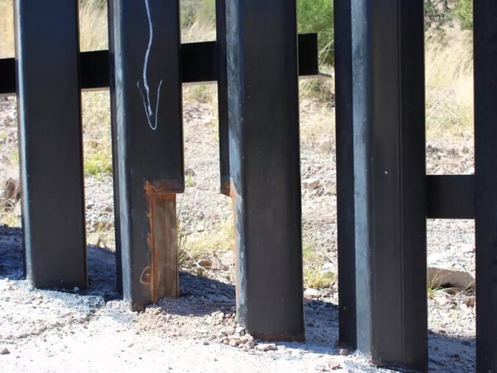 An arrow points to a wildlife passage built into the U.S-Mexico border wall near Nogales, Arizona, which allows small animals like bobcats and javelina to pass through but prevents larger animals like deer, mountain lions and bears. (Joe Duhownik/Courthouse News)