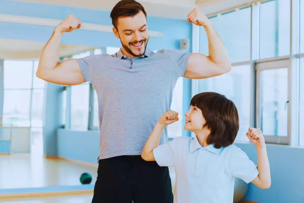 A father and son flex their muscles together