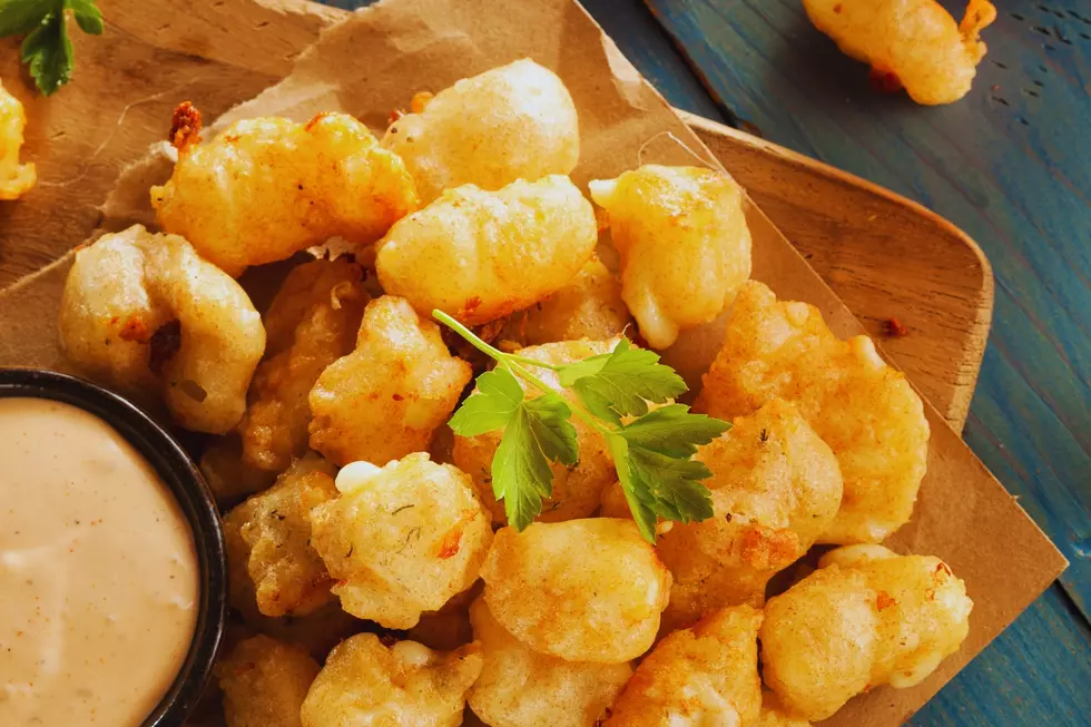 A bunch of cheese curds on a plate with dipping sauce