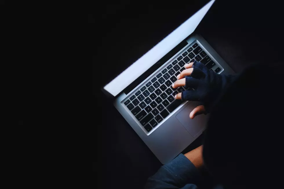 Hacker Hand Stealing Data from Laptop Top down