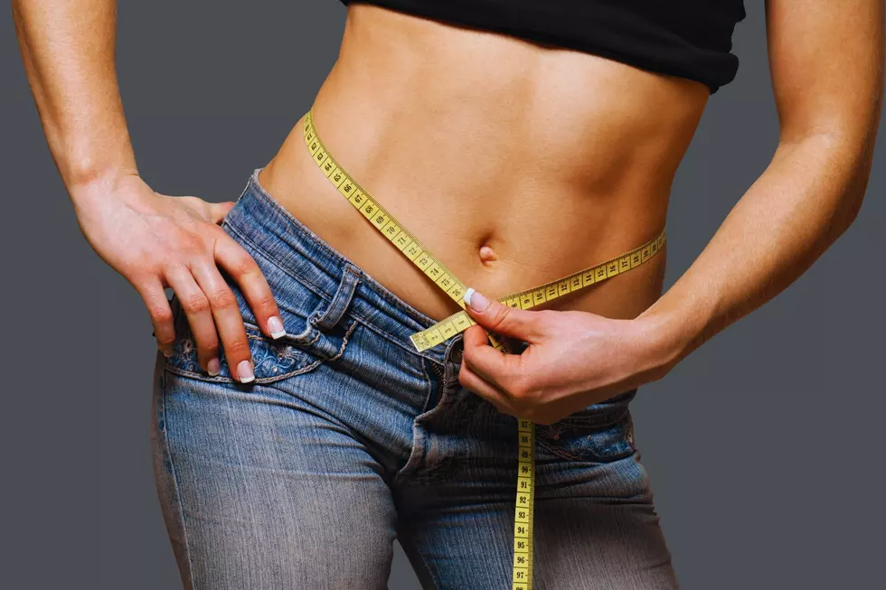 A woman has a tape measure around her waist