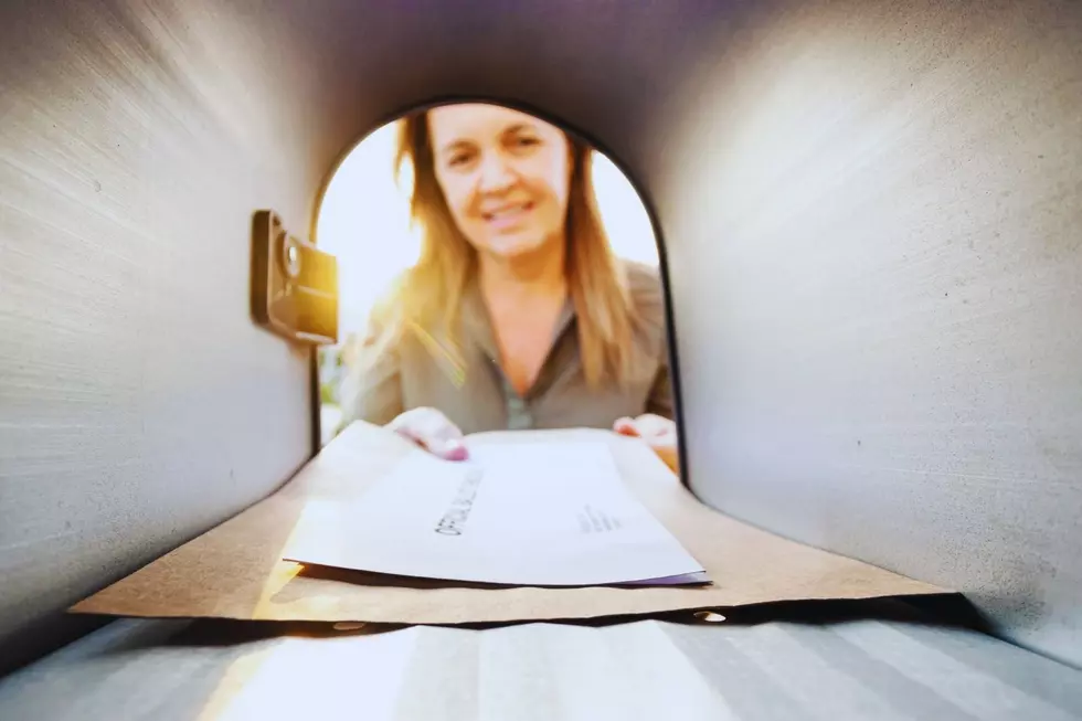 A woman is checking her mailbox for mail