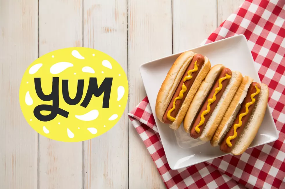 3 hot dogs on a plate sitting on a checkerboard tablecloth with a graphic that says yum