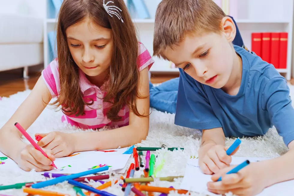 a boy and a girl drawing on the floor