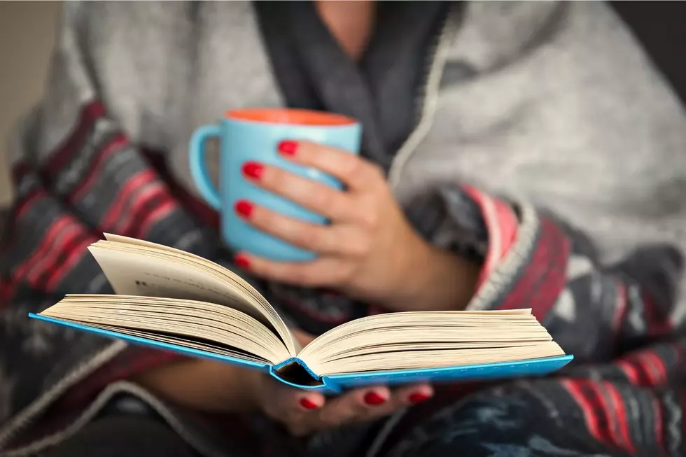 Woman reading a book and drinking coffee