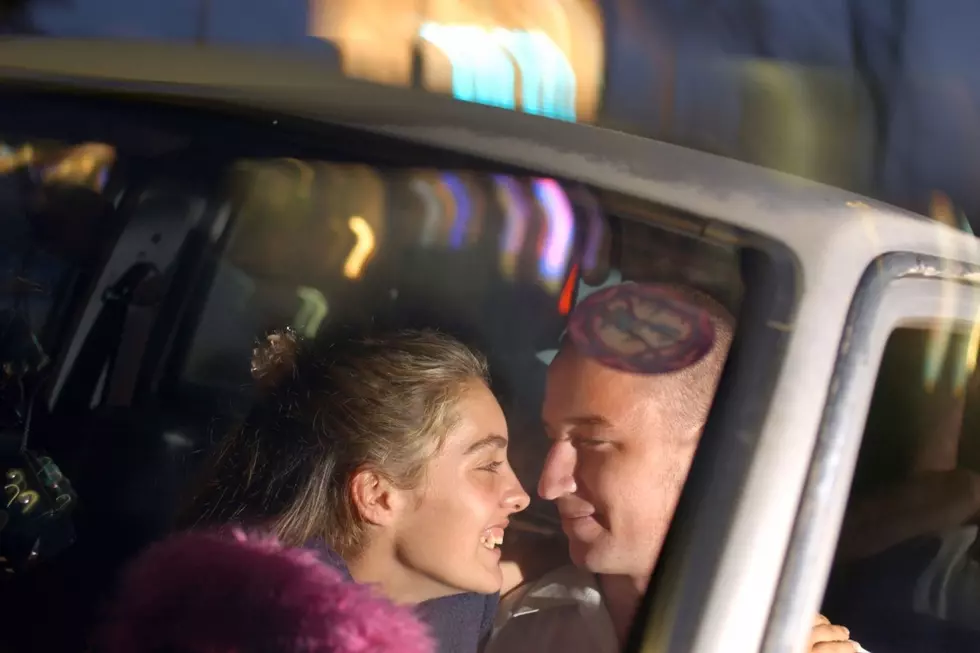 Two teens about to kiss in a car