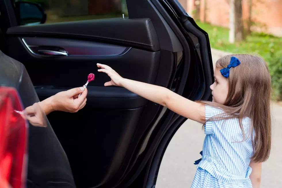 Girl takes a lollipop from a stranger in a car