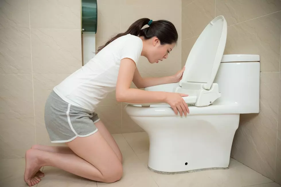 Woman vomits in a toilet