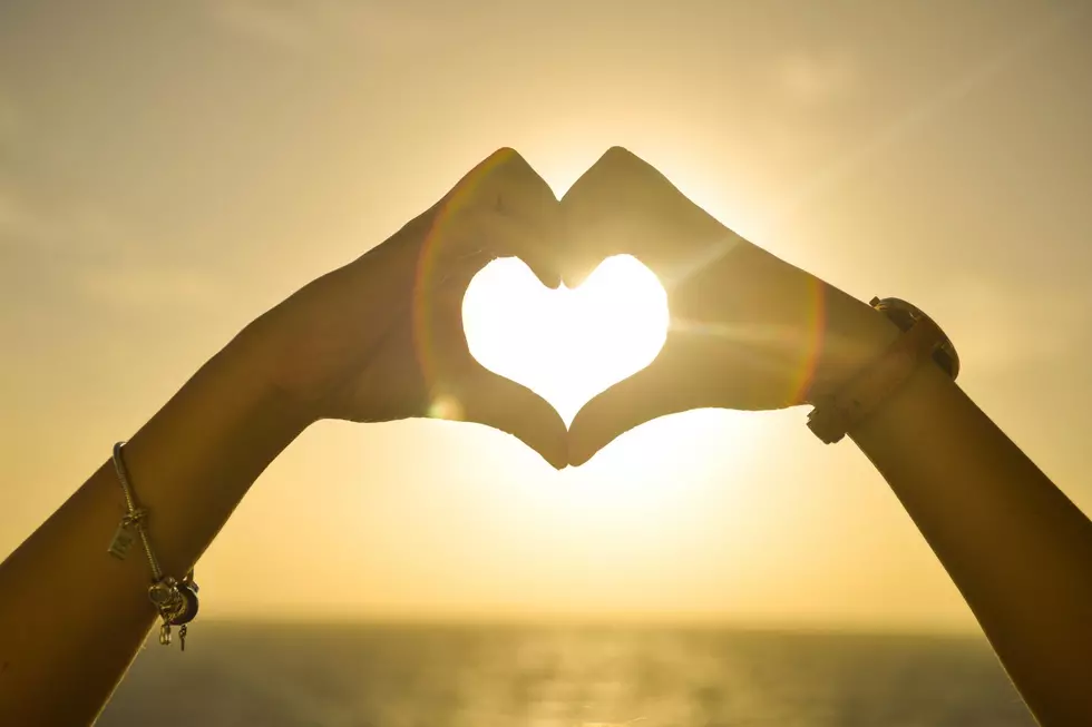 Heart hands over the sun