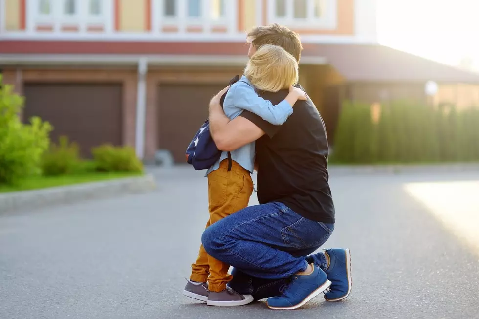 A young boy hugs his dad