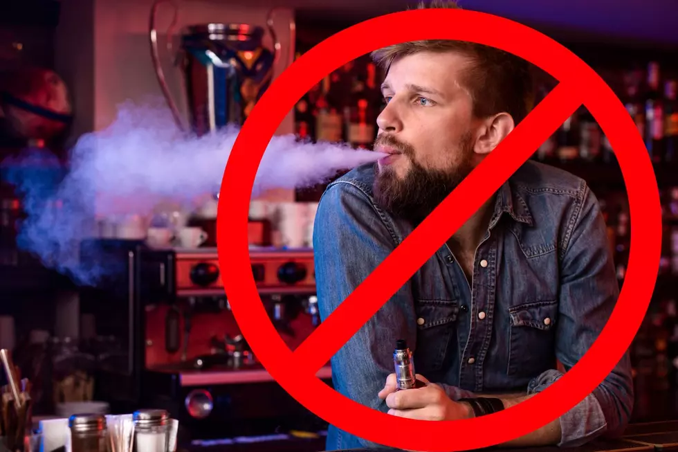 A man vaping with a giant "No" sign over him