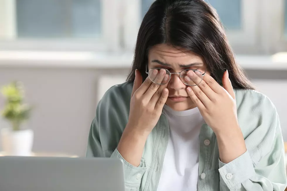A woman rubs her eyes