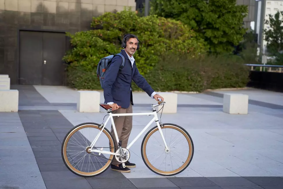 A man puts on headphones before riding his bike