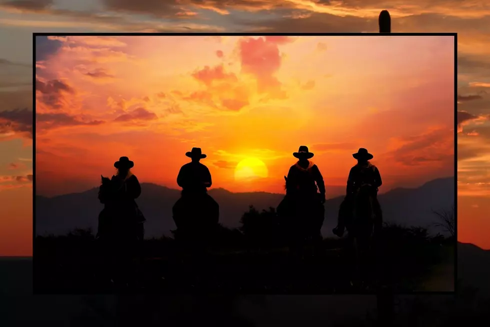 Four cowboys ride against the sunset