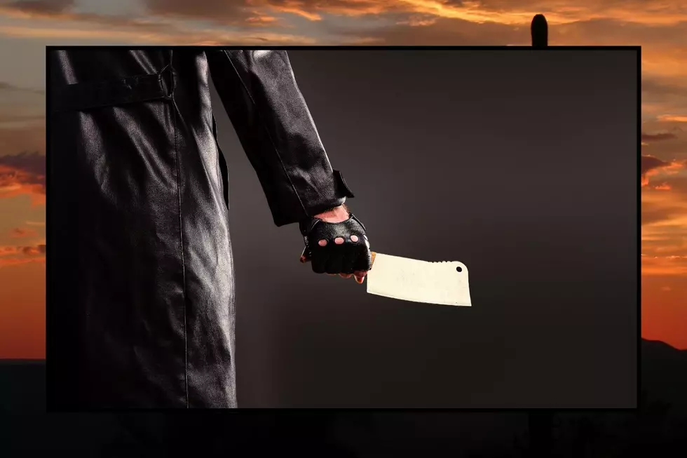 A man in a trench coat holding a butcher knife
