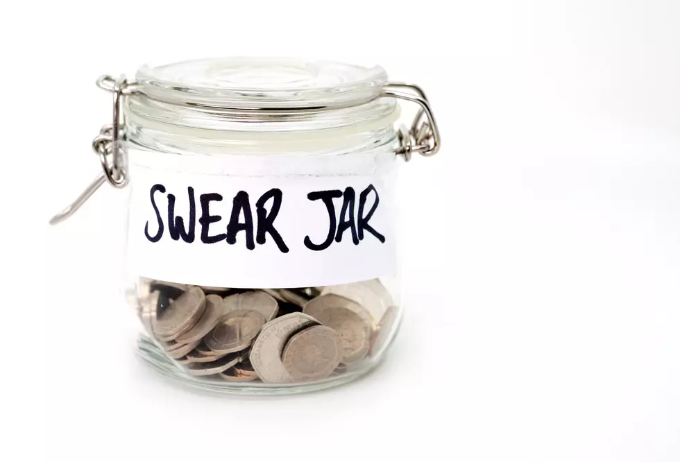 Swear jar with coins in on a white background
