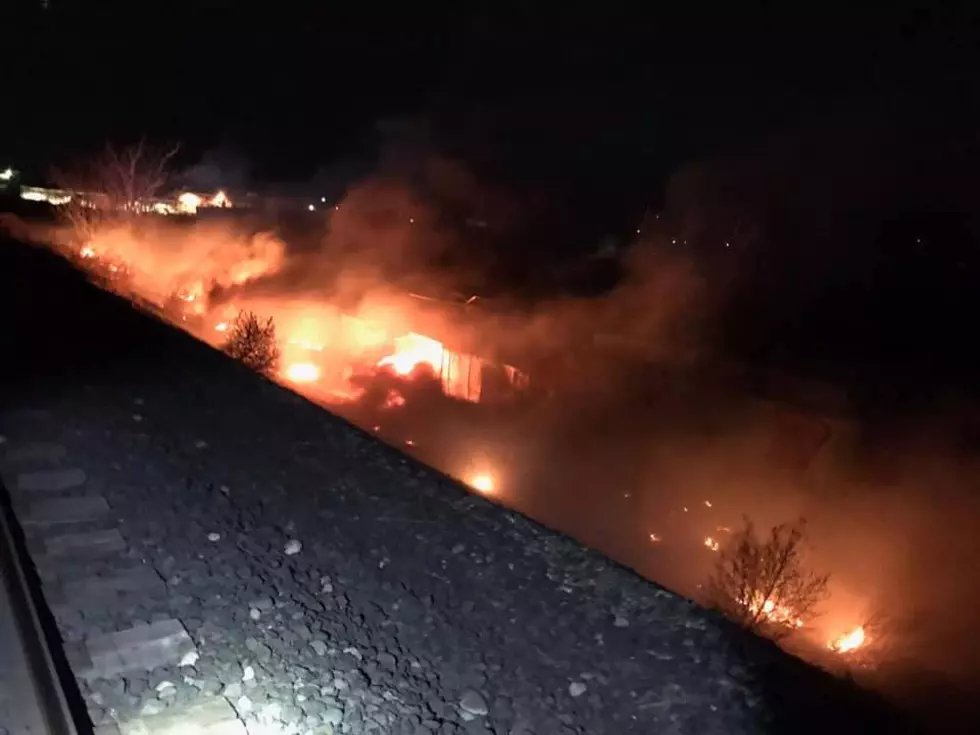 Suspicious fire burns brush, threatens buildings