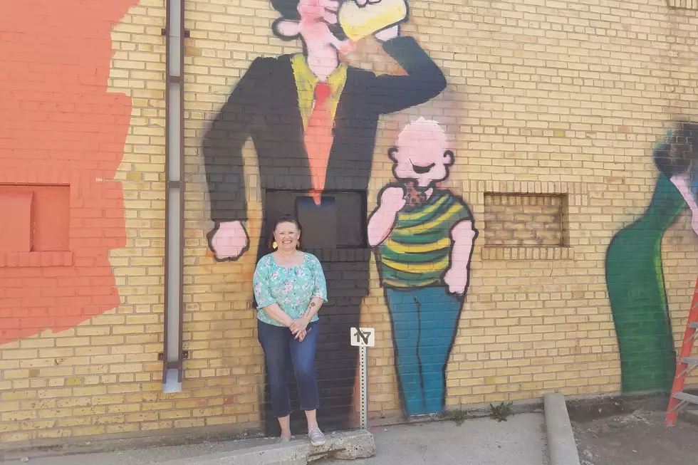 News Director Robin Travers in front of the sixth (and final) panel in the mural "Let's All Go To The Lobby" / Robin Travers