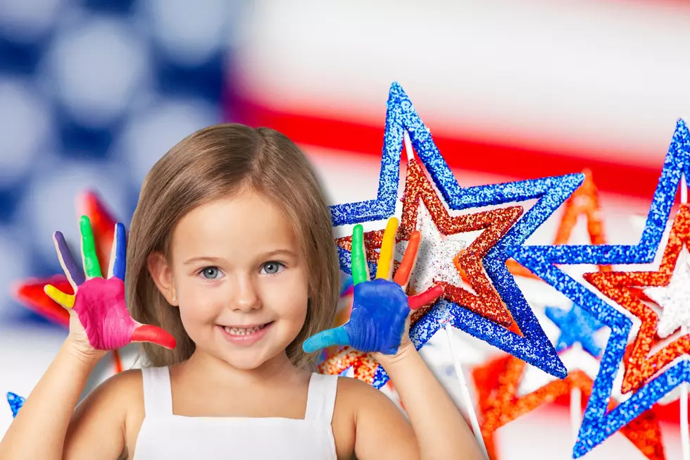 kid with finger paints in front of an american flag background