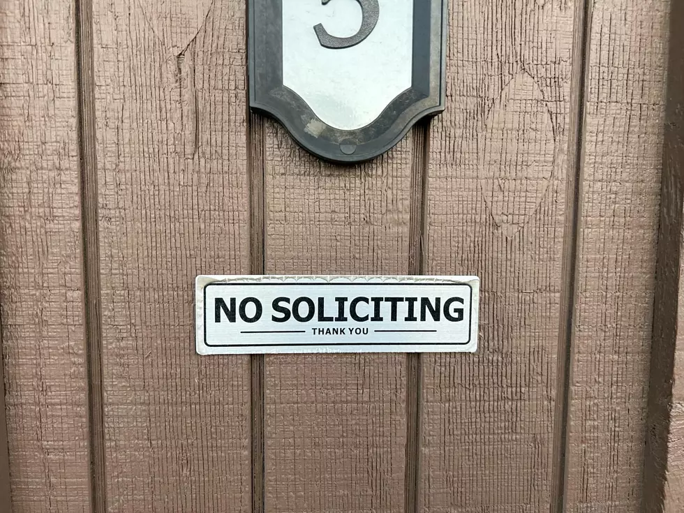 no soliciting sign on a brown house.