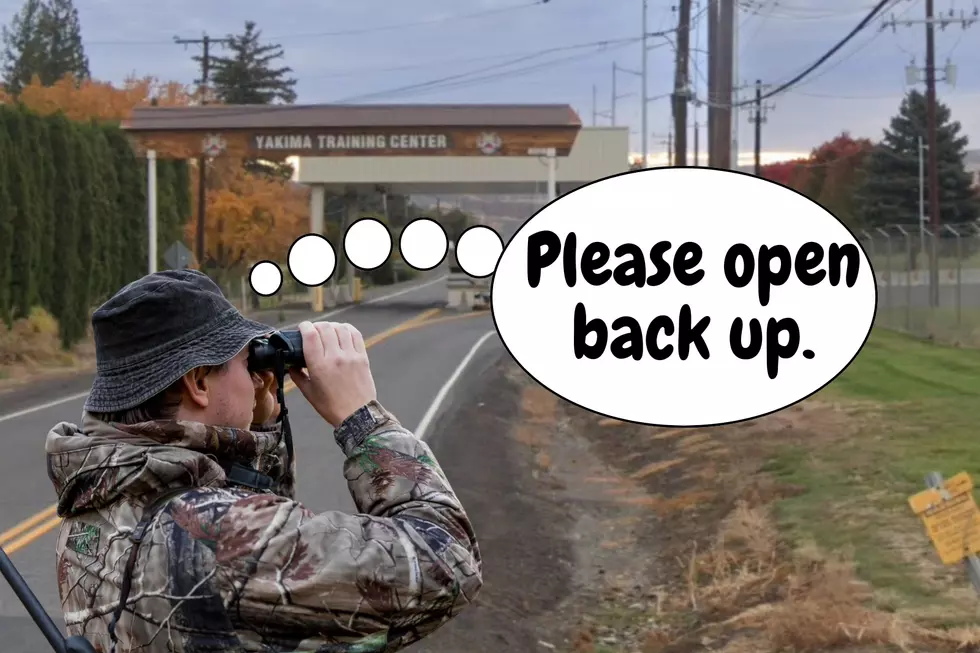 man with binoculars looking at a grassy area in front of a government area.