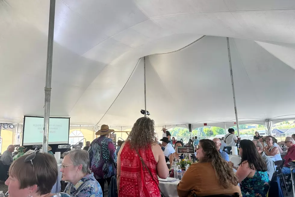 Tables of people eating food and excited to start the live auction.