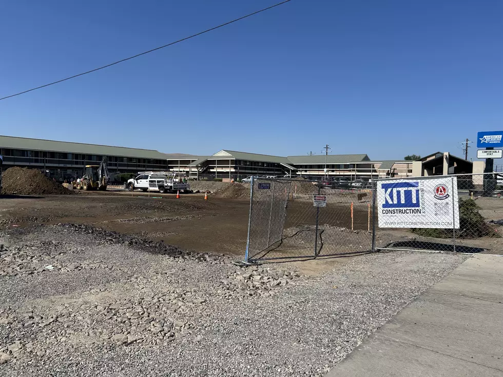 construction site, dirt, blue skies, buildings in background
