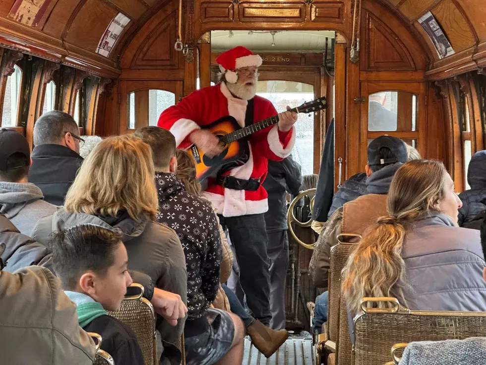 Santa playing a guitar on a crowded tour on the Yakima Trolley