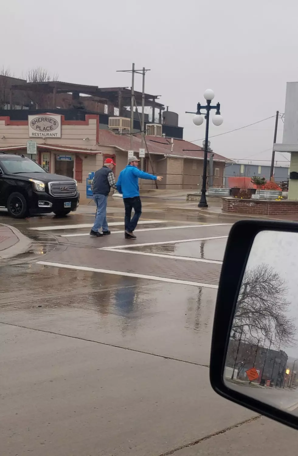 Man helping older gentleman cross the street