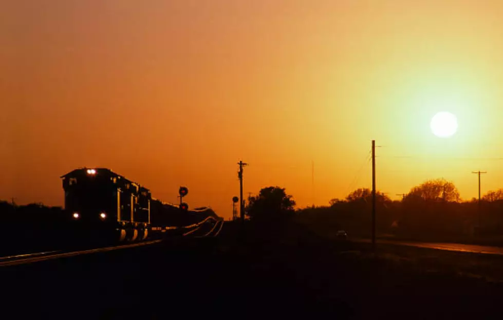 A coal train rolls across the Texas countryside at sunset on a spring day.