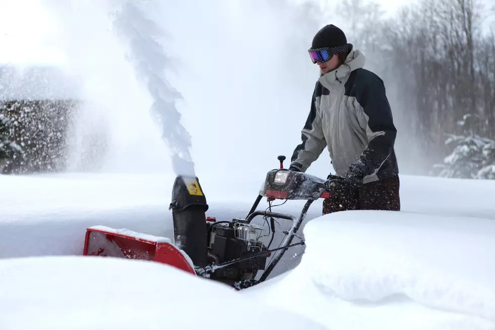man blowing snow