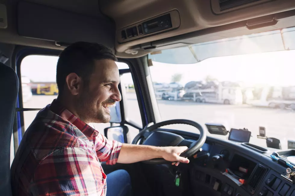 Truck driver job. Middle aged trucker driving truck.