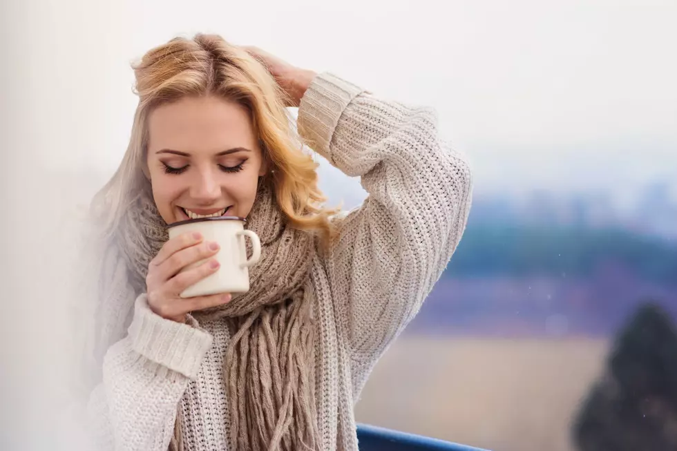 Beautiful woman relaxing at home with cup of coffee