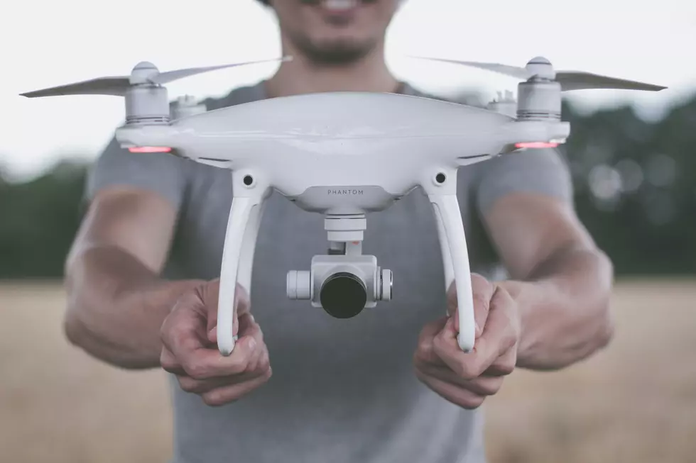 man smiles holding drone