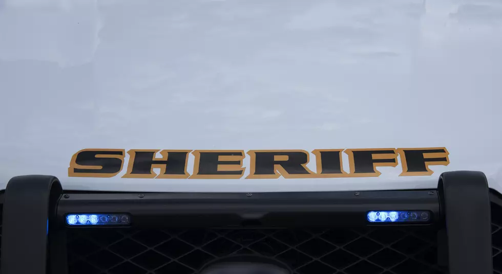 Flashing blue grill lights in the grill of a marked Sheriff's patrol vehicle.
