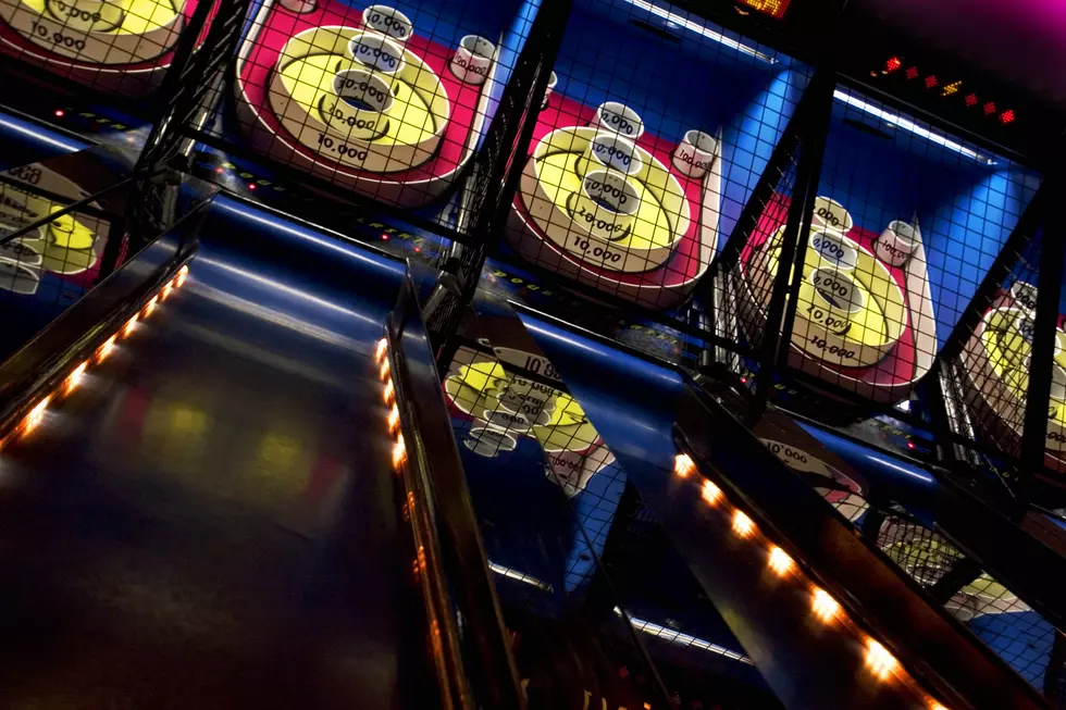 A series of skee-ball games lined up in an arcade. Try to roll 100,000.