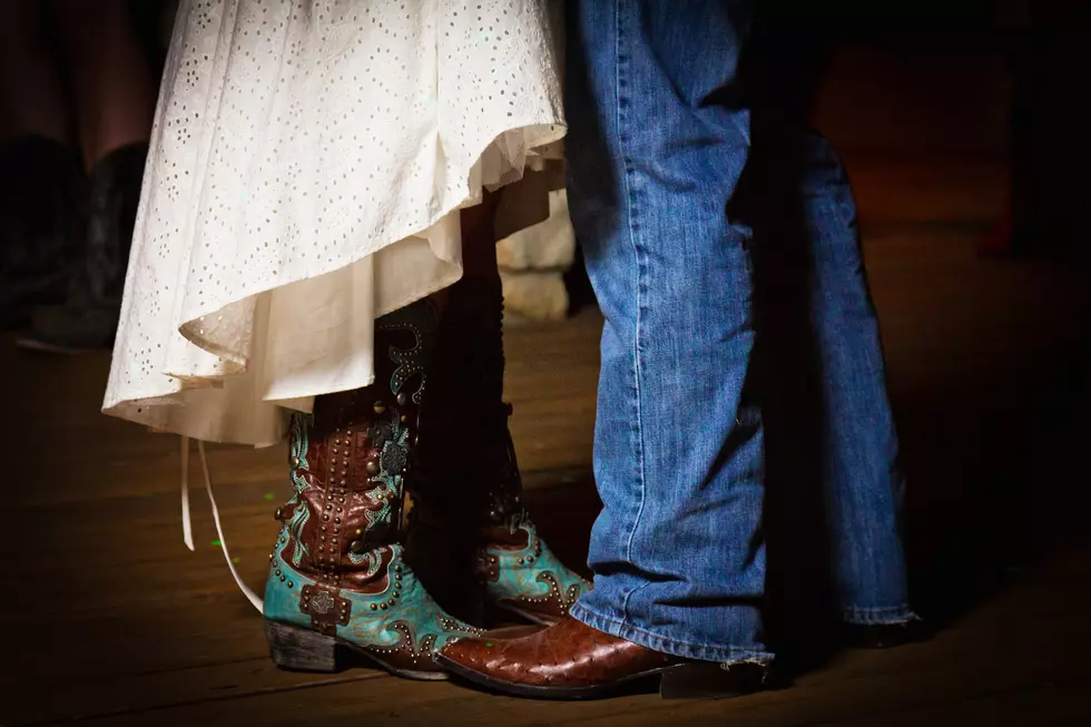 The bride and groom dancing in boots at a country wedding.