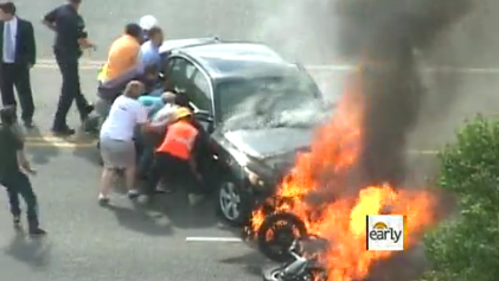 Bystanders Lift Flaming Car To Save Motorcyclist Trapped Underneath [AMAZING VIDEO]