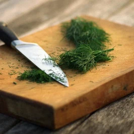 Herbs. Dill, knife and chopping board.